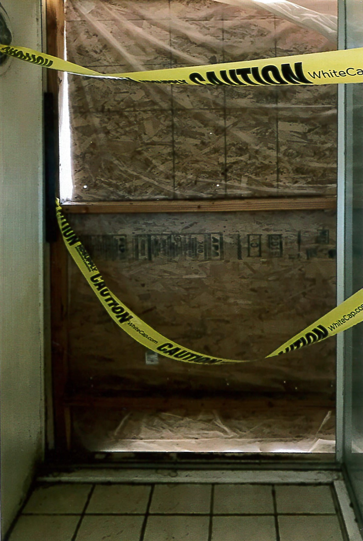 Shower, looking outward, exterior window has been boarded over